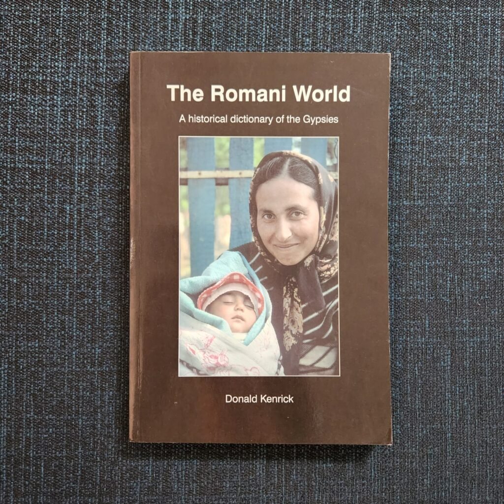 Cover of Donald Kenrick’s The Romani World: A Historical Dictionary of the Gypsies, featuring a central colour photograph of a woman holding a sleeping infant.